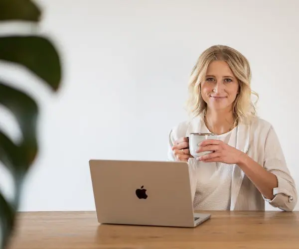Hero Bild Kontaktseite Foto Josy Schreier Katja Arndt, Webdesignerin sitzt am Laptop mit einer Tasse Kaffee