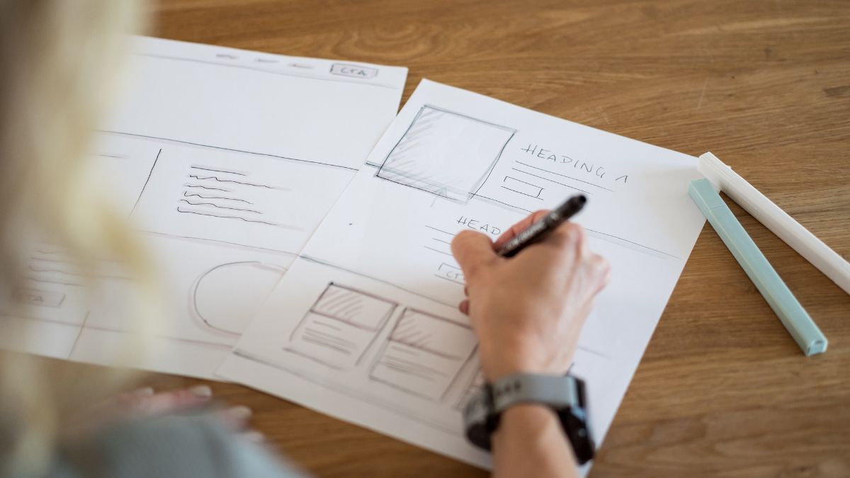 Hand skizziert Webdesign-Wireframes auf Papier auf einem Holztisch
